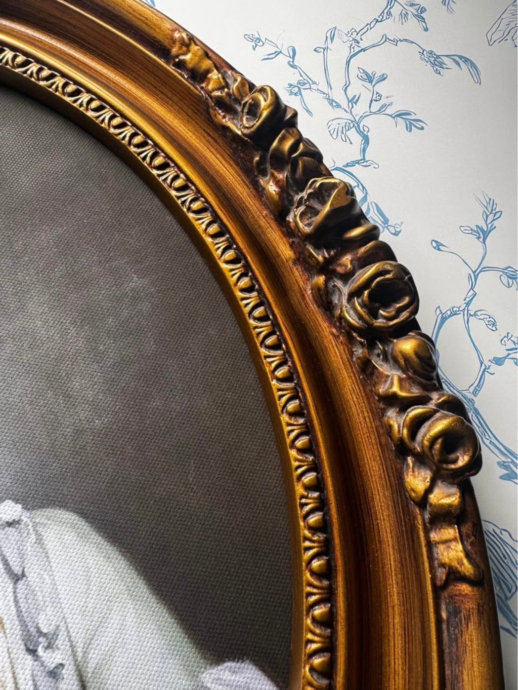 Side detail of antique oval frame and floral ornament