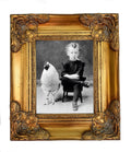 Black-and-white vintage photograph reproduction showing a seated boy beside a chicken